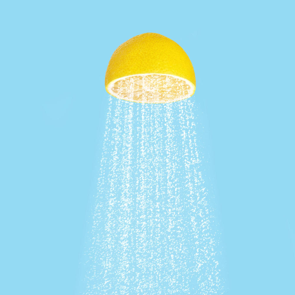 Wasser, das aus geschnittener Zitrone wie Duschkopf aussieht